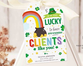 May include: A white gift tag with a green shamrock, rainbow, and pot of gold design. The text on the tag reads "I'm so very lucky to have awesome clients like you!"  The tag is tied with a white ribbon to a white triangular box.