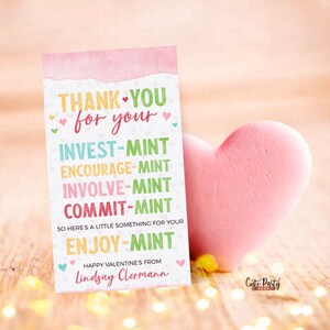 K&ouml;nnte beinhalten: Rosa und wei&szlig;e Karte mit dem Text "THANK YOU for your INVEST-MINT ENCOURAGE-MINT INVOLVE-MINT COMMIT-MINT SO HERE'S A LITTLE SOMETHING FOR YOUR ENJOY-MINT HAPPY VALENTINE'S FROM Lindsay Clermann".