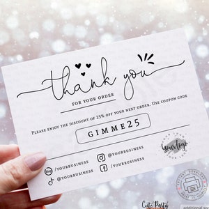 May include: A white thank you card with black text. The card says "thank you" with hearts and a starburst design. The card also says "For your order" and "Please enjoy the discount of 25% off your next order. Use coupon code GIMME25". The card has social media icons and a logo that says "Your logo".