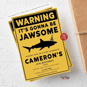 Puede incluir: Invitaci&oacute;n de fiesta de cumplea&ntilde;os amarilla y negra con un tibur&oacute;n que lleva un gorro de fiesta. El texto dice "Advertencia Va a ser Jawsome" y "Cameron's 4th Birthday".