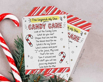 May include: Two red and white striped candy canes with a tag that reads "The Legend of the Candy Cane." The tag has a poem about the candy cane and is decorated with candy cane illustrations and stars. Green pine branches are at the bottom.