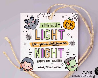 May include: A white card with a Halloween theme. It says "a little bit of LIGHT for your Halloween NIGHT" with a bat, pumpkin, and monster illustrations. It also says "HAPPY HALLOWEEN! xoxo, Name Here".