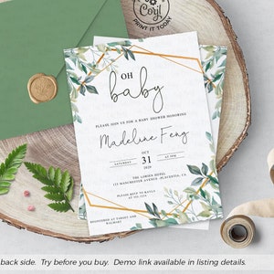 May include: A green envelope with a wax seal sits on a wooden surface next to a white baby shower invitation with gold geometric shapes and green foliage. The invitation reads "Oh baby" and "Madeline Feng".