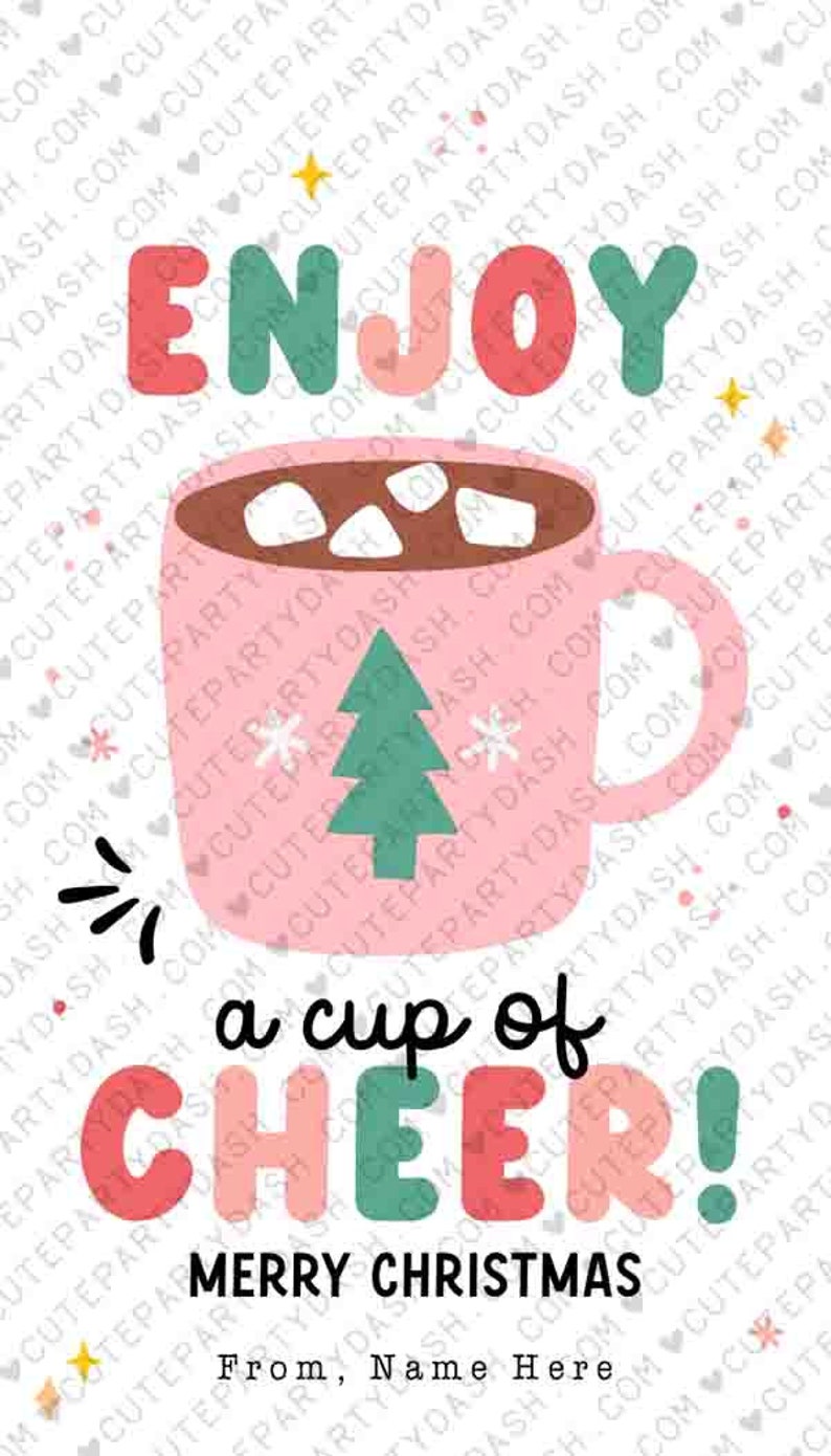 May include: A pink mug with a brown liquid and white marshmallows inside. The mug has a green Christmas tree and snowflakes on it. The text "Enjoy a cup of cheer! Merry Christmas" is written in colorful letters. The text "From, Name Here" is written below the Christmas greeting.