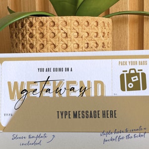 May include: A gold and white printable weekend getaway ticket with the text "Pack Your Bags" and "You Are Going On A Weekend Getaway". The ticket has a space for a message and a fold-over flap with a staple hole to create a pocket for the ticket.