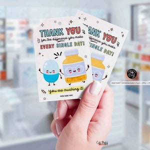 Puede incluir: Tarjeta de agradecimiento con un dise&ntilde;o de p&iacute;ldora y botella de dibujos animados. La tarjeta dice "&iexcl;Gracias por la diferencia que haces cada d&iacute;a! &iexcl;Lo est&aacute;s aplastando!"
