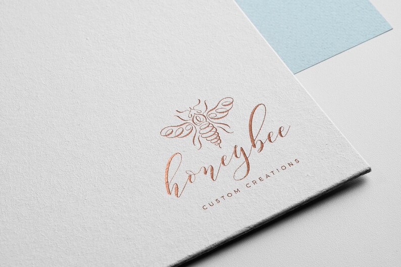 Pu&ograve; includere: Un logo per un'azienda chiamata "honeybee custom creations" con un disegno stilizzato di un'ape in color rame.