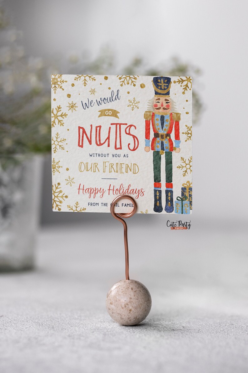 May include: A Christmas card featuring a watercolor illustration of a nutcracker holding a gift. The card reads "We would go nuts without you as our friend. Happy Holidays from the [Il] family."