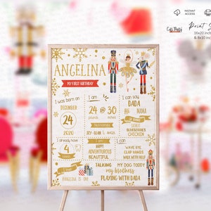 May include: A gold and white printable first birthday sign featuring a Nutcracker theme. The sign includes the name "Angelina" and details about her first year, including her birthdate, weight, height, and milestones.