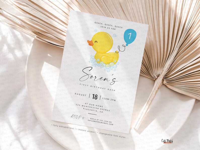 May include: A printable first birthday party invitation featuring a yellow rubber ducky with a blue balloon. The invitation says "Soren's First Birthday Bash" and includes the date, time, and location of the party. RSVP information is also included.