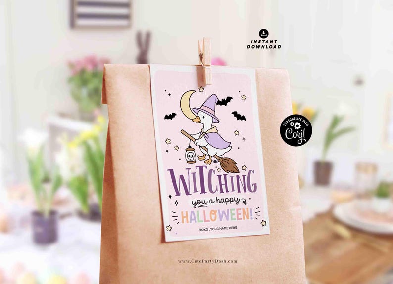 May include: A Halloween-themed gift bag with a light pink tag featuring a cartoon witch duck riding a broom. The tag reads "Witching you a happy Halloween!" with bats, stars, and a crescent moon. The bag is brown.