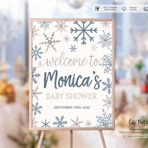 May include: A white welcome sign with a blue and gray snowflake design. The sign says "Welcome to Monica's Baby Shower" and "September 19th, 2020".