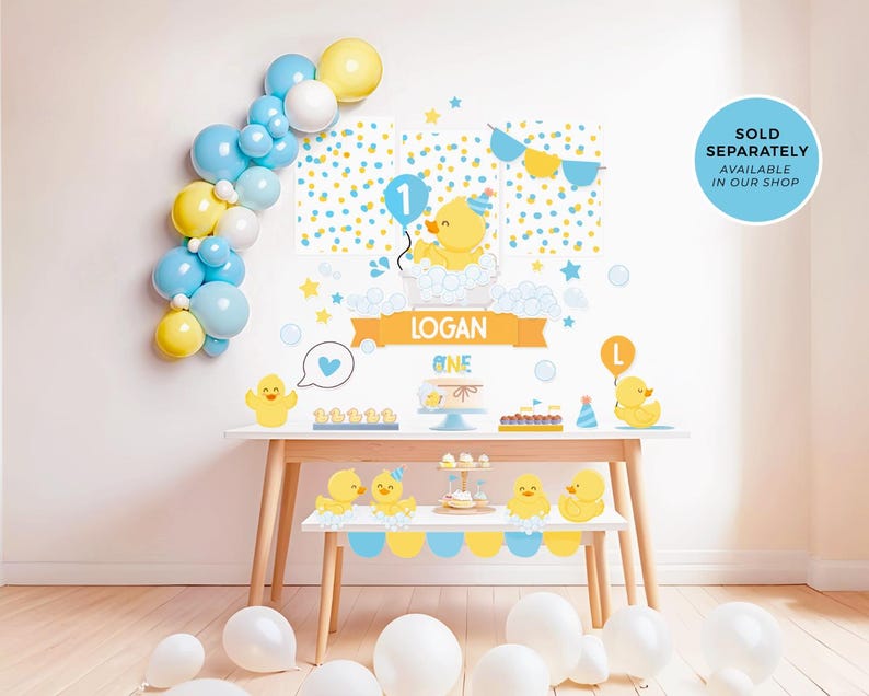 May include: A yellow and blue birthday party backdrop with a rubber ducky theme. The backdrop features a yellow rubber ducky with a party hat, a blue balloon, and the number one. The backdrop also includes the name "Logan" and the word "One".