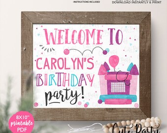 May include: Printable 8x10 inch welcome sign for a birthday party. The sign features a pink and blue castle with a balloon and the text "Welcome to Carolyn's Birthday Party!" in a colorful, whimsical font.