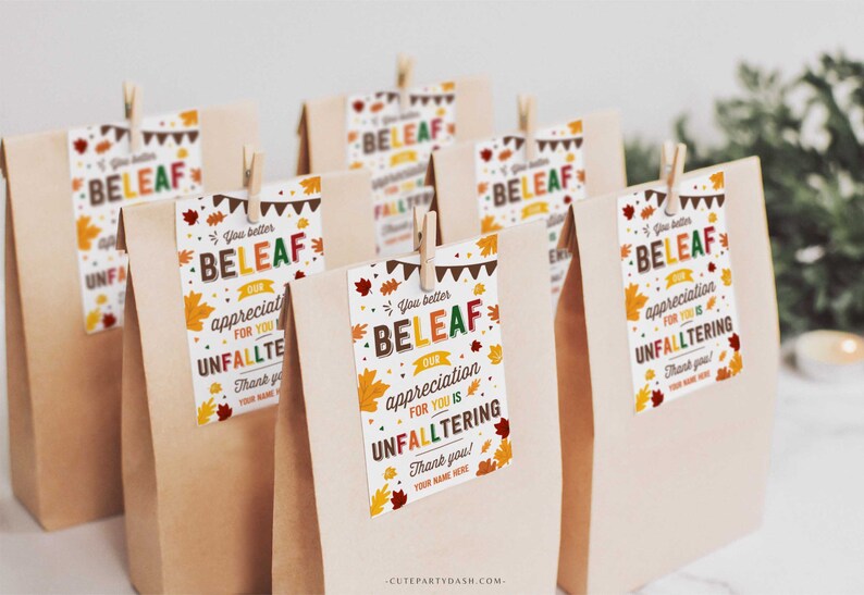 May include: A set of brown paper bags with colorful fall-themed gift tags that say "You better BELEAF our appreciation for you is UNFALLTERING".