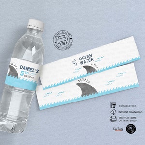 May include: Water bottle labels with a blue and white ocean wave design and a gray shark fin. The label says "Ocean Water" and has the text "Daniel's 5th Birthday".