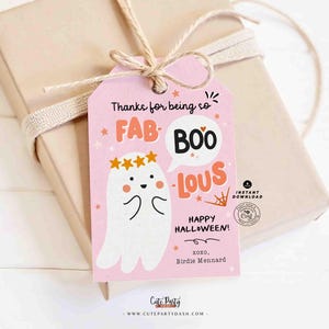 May include: A pink Halloween gift tag with the words "Thanks for being so FAB-BOO-LOUS!" and "Happy Halloween!" A cute ghost illustration is featured. The tag is tied to a wrapped gift with twine.