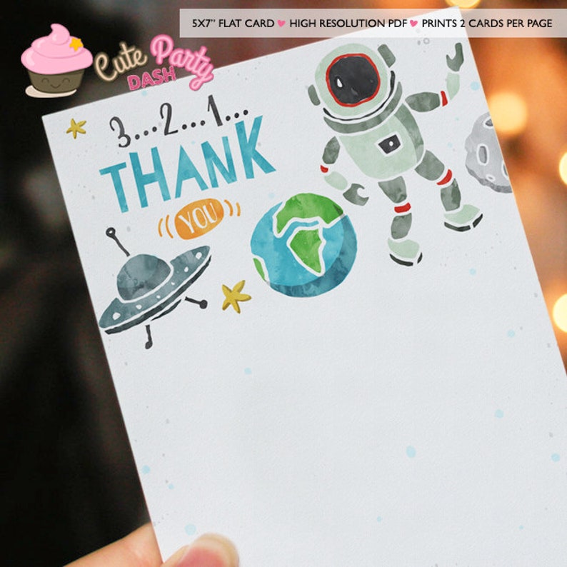 May include: A thank you card with a space theme. The card features a cartoon astronaut, a spaceship, a planet Earth, and stars. The text on the card reads "3...2...1... THANK (YOU)".