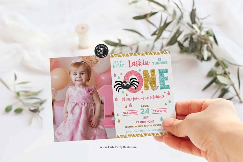 May include: A pink and blue birthday invitation with a glittery gold number one and a black spider. The invitation says "Itsy Bitsy Larkin is turning one" and includes the date and time of the party. A photo of a young girl is included in the background.
