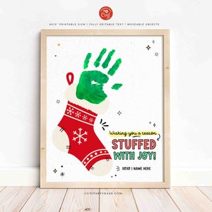 May include: A printable Christmas sign featuring a red stocking with a green handprint inside. The sign says "Wishing you a reason stuffed with joy!" and has space for a name.