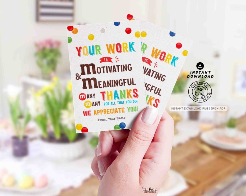 Op de afbeelding: Twee witte cadeaulabels met de tekst "Uw werk is motiverend en betekenisvol. Veel dank voor alles wat u doet! We waarderen u!" en kleurrijke snoepaccenten. De labels worden in een hand gehouden.
