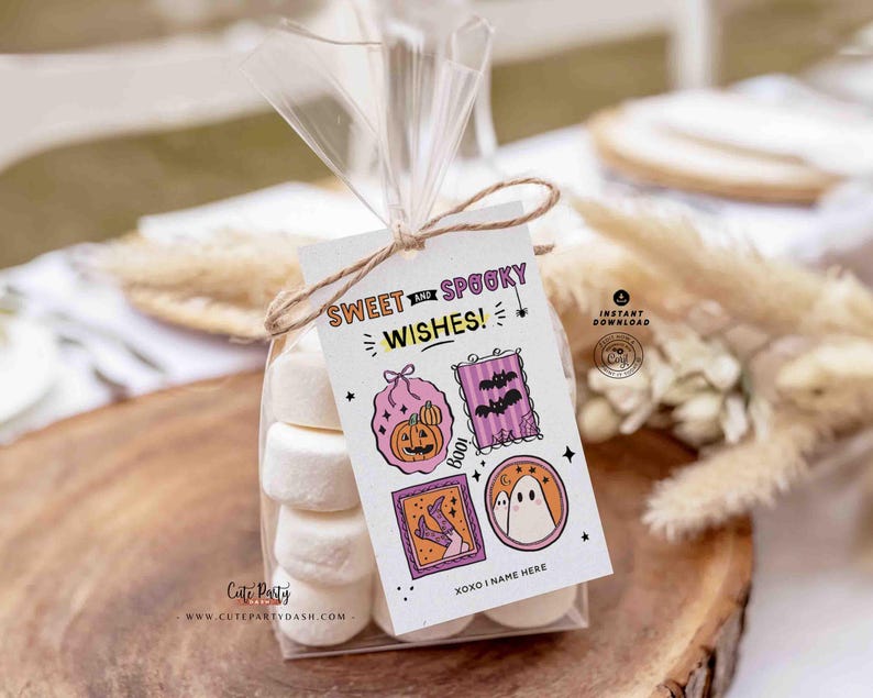 Pu&ograve; includere: Un sacchetto trasparente pieno di marshmallow bianchi, legato con spago e un'etichetta decorativa. L'etichetta recita "Sweet and Spooky Wishes!" e presenta illustrazioni a tema Halloween di una zucca, pipistrelli e un fantasma. Il sacchetto &egrave; su una superficie di legno.
