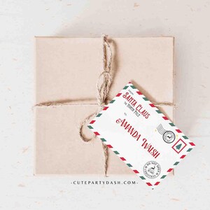 May include: A red and green Christmas gift tag with a white background. The tag is shaped like an envelope and has the text "Santa Claus, The North Pole" and "Amanda Walsh" on it. The tag also has a red and green stamp that says "Do Not Open Until Christmas".