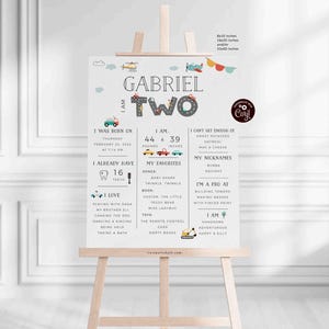 May include: A white printable birthday sign with a gray and white car theme. The sign says "Gabriel is Two" and includes details about the child's age, weight, height, favorite foods, and more.