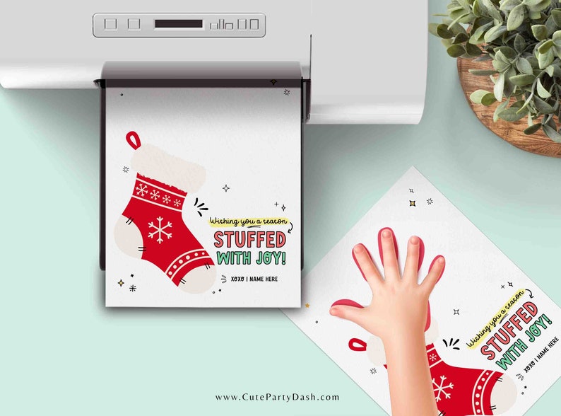 May include: A printable Christmas card with a red stocking and the text "Wishing you a season stuffed with joy!"  The card is being printed on a white printer.