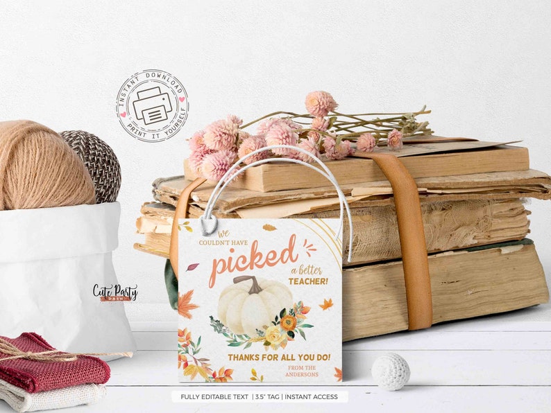 May include: A printable teacher appreciation gift tag with a fall theme. The tag features a white pumpkin with orange and yellow flowers and leaves. The text reads "We couldn't have picked a better teacher! Thanks for all you do! From the Andersons".