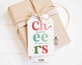 Könnte beinhalten: Ein druckbarer Geschenkanhänger mit dem Wort "cheers" in bunten, stilisierten Buchstaben. Der Anhänger enthält auch den Text "Happy Holidays" und "xoxo Sabrina + Doug".
