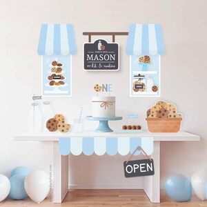 May include: A blue and white striped awning with a sign that reads "Since 2023 Mason Milk & Cookies" and a sign that says "Open". There are also several cookies, milk bottles, and balloons in the image.