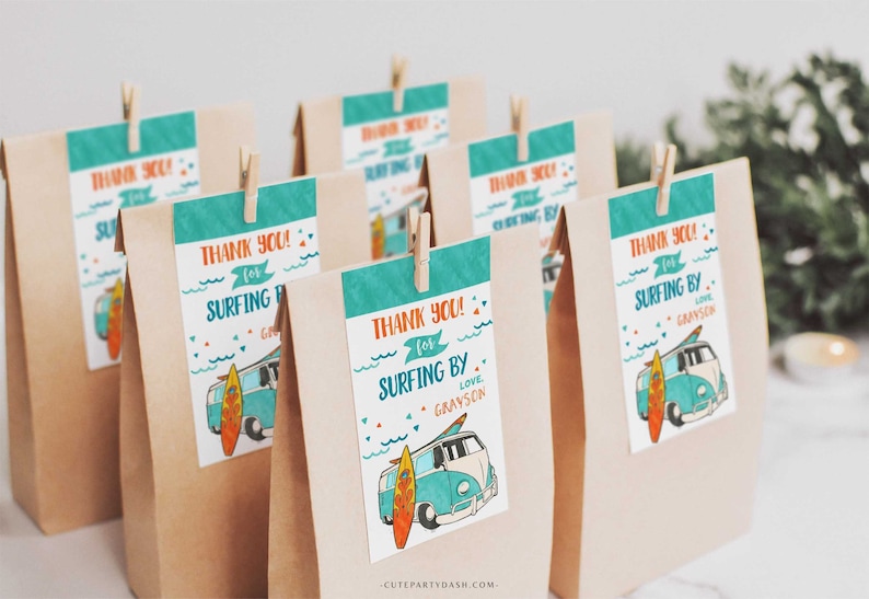 May include: Brown paper bags with turquoise and orange thank you tags. The tags feature a cartoon illustration of a blue and white van with a surfboard on the side. The text on the tags reads "Thank you! for surfing by. Love, Grayson".