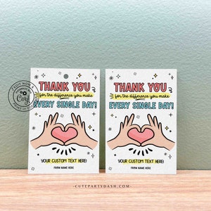 May include: Two white thank you tags with a pink heart and two hands making a heart shape. The text on the tags reads "Thank you for the difference you make every single day!" and "Your custom text here!"