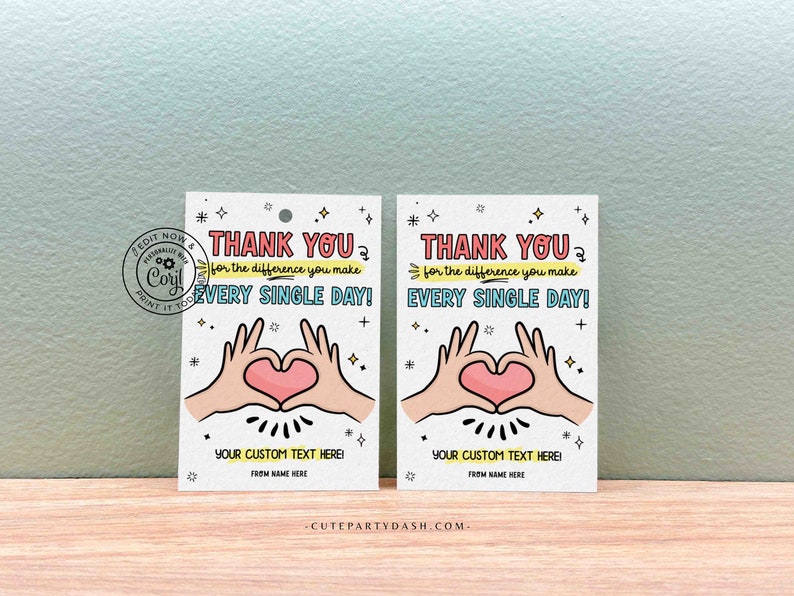 May include: Two white thank you tags with a pink heart and two hands making a heart shape. The text on the tags reads "Thank you for the difference you make every single day!" and "Your custom text here!"