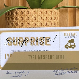 May include: A printable surprise ticket template with the text "Surprise!" and "Let's take a drive!" with a car icon. The text "Pack your bags! You are going to..." and "Type message here" are included. The template includes a sleeve to create a pocket for the ticket.