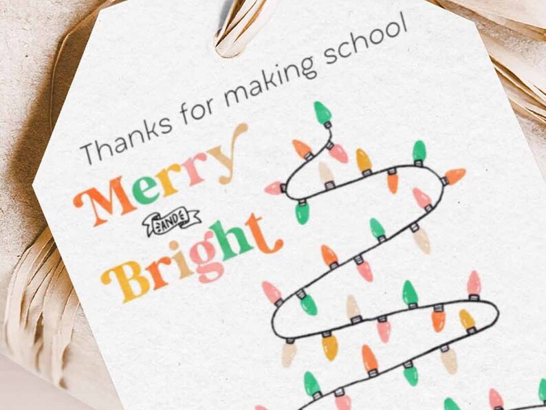 May include: A white gift tag with the text "Thanks for making school Merry & Bright" in colorful letters. A string of colorful lights is drawn on the tag.