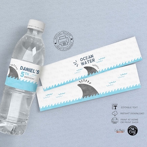 May include: Printable water bottle labels featuring a blue ocean wave design and a grey shark fin. The labels read "Ocean Water" and "Daniel's 5th Birthday".