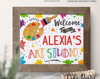 May include: A framed art print with a watercolor design. The print features a paint palette, paint brush, and colorful paint splatters. Text reads "Welcome to Alexia's Art Studio." The frame is made of wood. The sign is 8x10 inches.