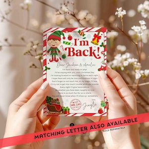 May include: A red and white striped card with a cartoon elf and the text "I'm Back!"  The card has a message for Jackson and Amelia, saying the elf will be staying with them until Christmas Day.  The card also has a Santa Claus stamp and the word "Jingle".