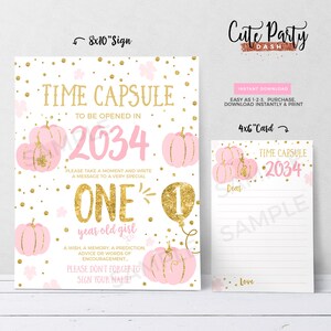 May include: A pink and gold time capsule sign with a pumpkin theme. The sign says "Time Capsule to be opened in 2034" and "One year old girl". It also includes a space for people to write messages.