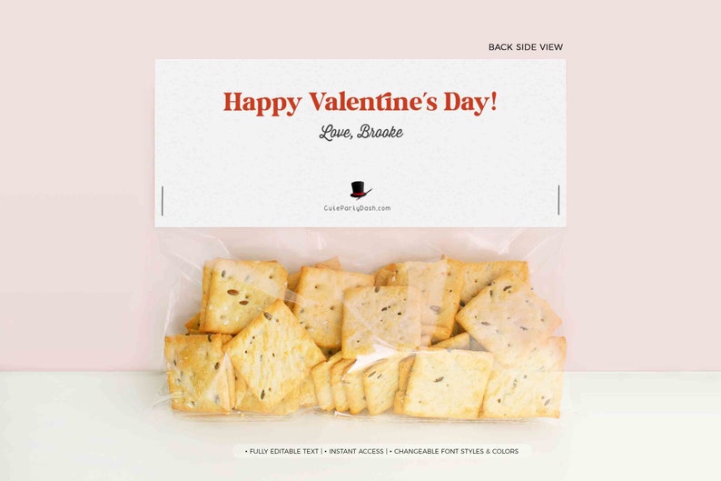 May include: A clear plastic bag filled with square crackers. A white card with the text "Happy Valentine's Day! Love, Brooke" is attached to the bag.