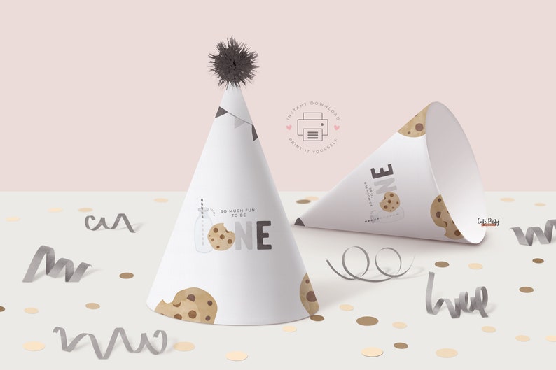 Peut inclure: Chapeau de f&ecirc;te imprimable avec un motif de cookie et le texte "So much fun to be one". Le chapeau est blanc avec des illustrations de cookies marrons et noirs. Le chapeau est pos&eacute; sur une surface blanche avec des confettis.