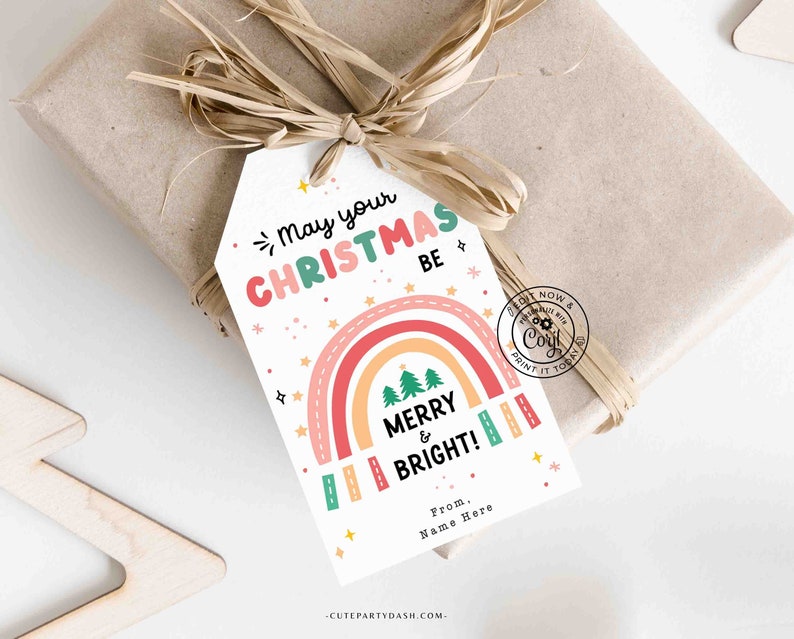 May include: A white gift tag with a rainbow, Christmas trees, and the text "May your Christmas be Merry & Bright!"  From. Name Here. -CUTEPARTYDASH.COM-