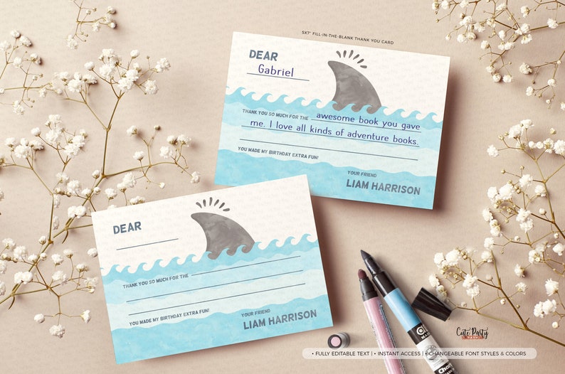 May include: A blue and grey thank you card with a shark fin design. The card says "Dear [Name], Thank you so much for the [Gift]. I love all kinds of adventure books. You made my birthday extra fun! Your friend, Liam Harrison."