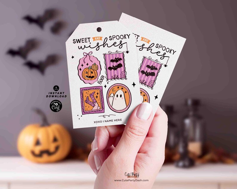 Może przedstawiać: Dwie białe etykiety prezentowe na Halloween ze słowami "Sweet and Spooky Wishes" i r&oacute;żnymi upiornymi ilustracjami. Etykiety przedstawiają dynię, nietoperze, ducha i tekst "Boo!". Etykiety są trzymane przez osobę.