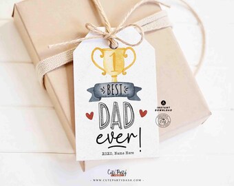 May include: A gift tag with the text "Best Dad Ever!" in black and white, featuring a gold trophy illustration and two red hearts. The tag is tied to a wrapped gift with twine.