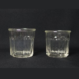 Peut inclure: Deux bocaux en verre transparent avec un motif texturé. Les bocaux sont vides et ont une forme ronde.