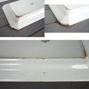 May include: White ceramic serving platter with a slightly raised rim and a slightly scalloped edge. The platter has a few brown stains on the bottom.
