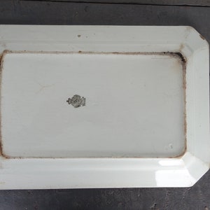 May include: White rectangular ceramic serving platter with a slightly raised rim and a beveled edge. The platter has a black stamp on the bottom that reads "GRANDE LUNEVILLES FRANCE".